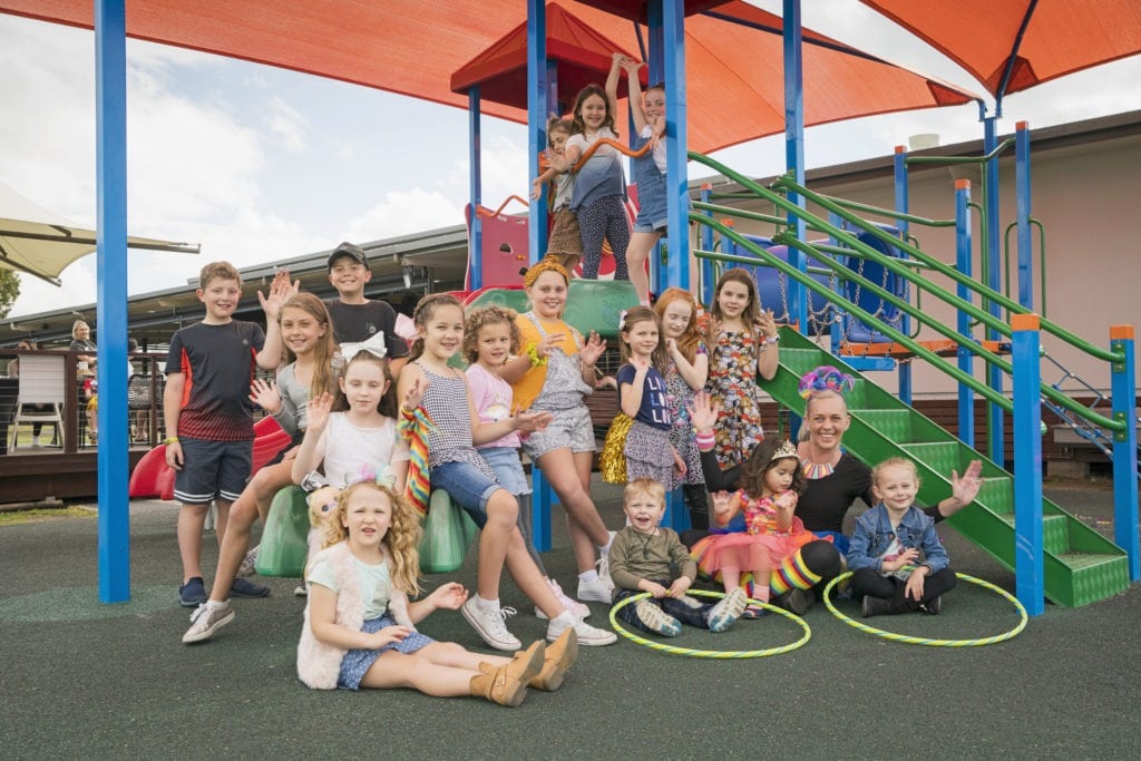Group of children playing and posing on the colourful playground at Cherry Street Sports in Ballina, with entertainers and party fun.