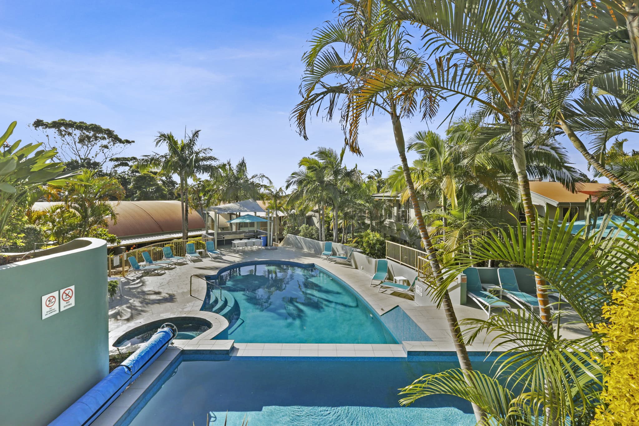 Tropical resort-style pool surrounded by palm trees at Lennox Beach Resort in Lennox Head NSW