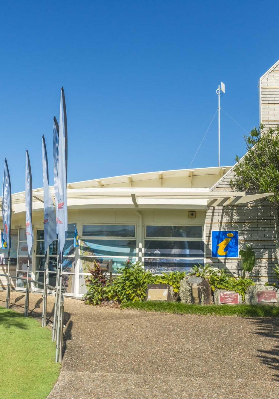 visitor centre building with path leading to entrance and flags out the front