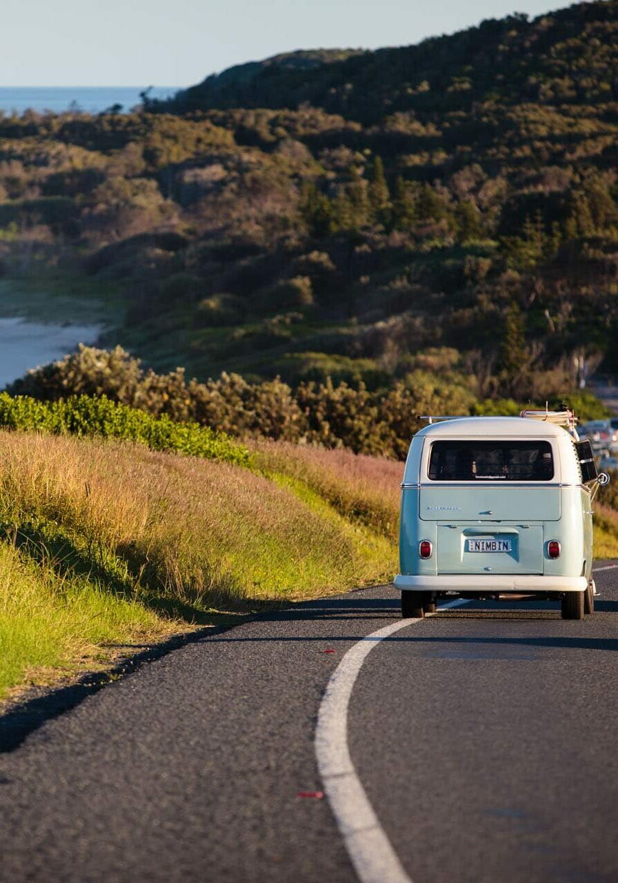 Classic Kombi van driving along the scenic Coast Road between Lennox Head and Ballina, with ocean views and lush greenery.